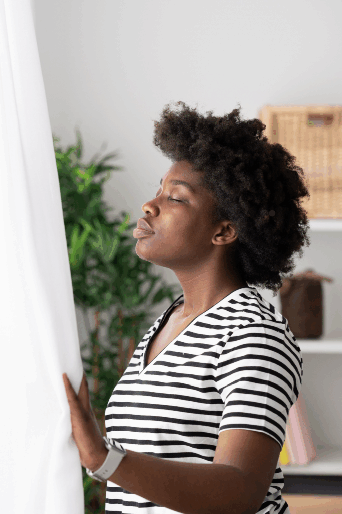 Woman inhales a deep breath while looking out the window of her Las Vegas Home